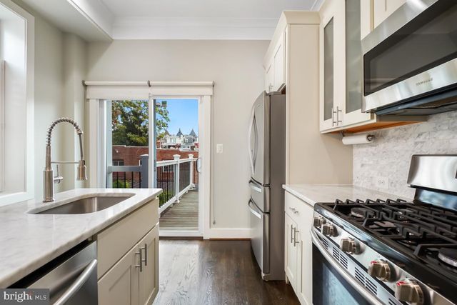 a kitchen with granite countertop a stove and a refrigerator