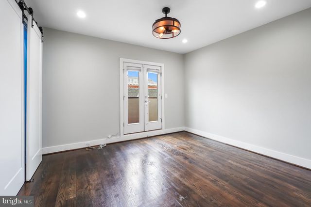an empty room with wooden floor and window