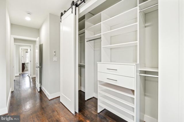 a view of walk in closet with empty racks
