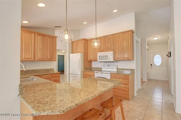a kitchen with stainless steel appliances granite countertop a sink refrigerator and cabinets