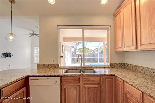 a kitchen with granite countertop a sink a counter space and cabinets