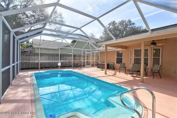 a view of a swimming pool with a patio and a backyard