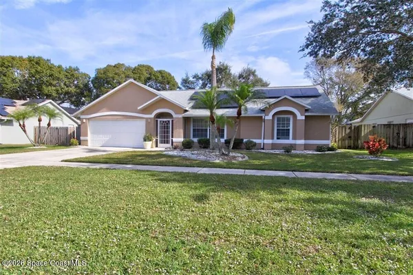 a front view of a house with a garden and trees