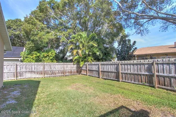 a view of a yard with wooden fence