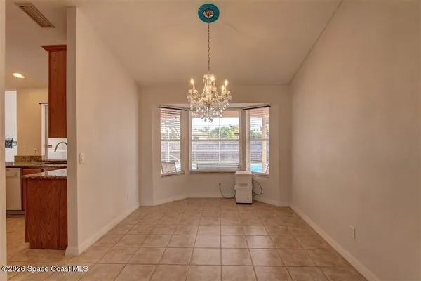 a view of a livingroom with a chandelier fan and windows