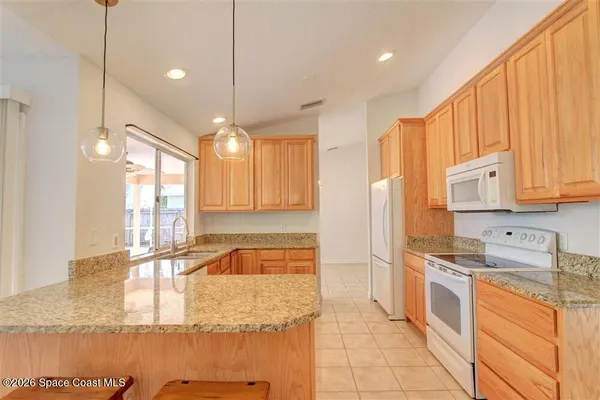 a large kitchen with kitchen island granite countertop a large window cabinets and stainless steel appliances