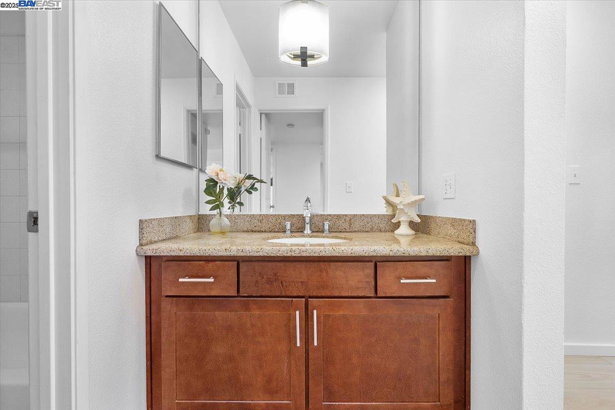 1318 B Street, Unit 314 Hayward, CA 94541 - Photo 15 of 20 a bathroom with a granite countertop sink and a mirror