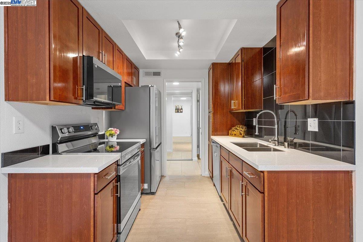 1318 B Street, Unit 314 Hayward, CA 94541 - Photo 7 of 20 a kitchen with stainless steel appliances granite countertop a sink stove and cabinets
