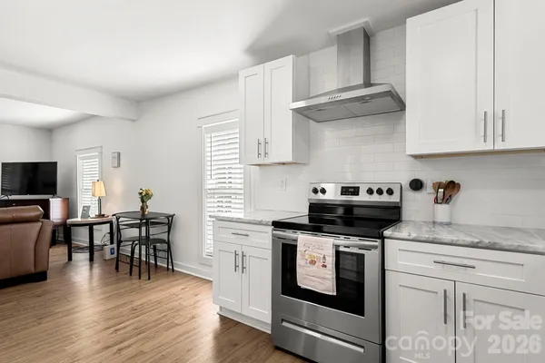 a kitchen with stainless steel appliances granite countertop a stove and a wooden floors