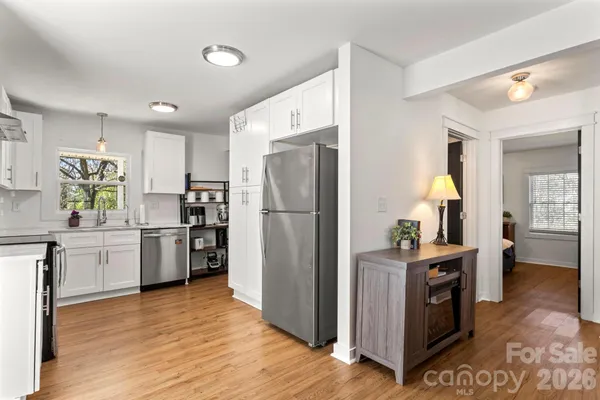 a kitchen with a refrigerator and a wooden floor