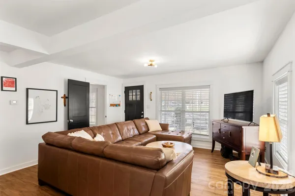 a living room with furniture flat screen tv and a large window