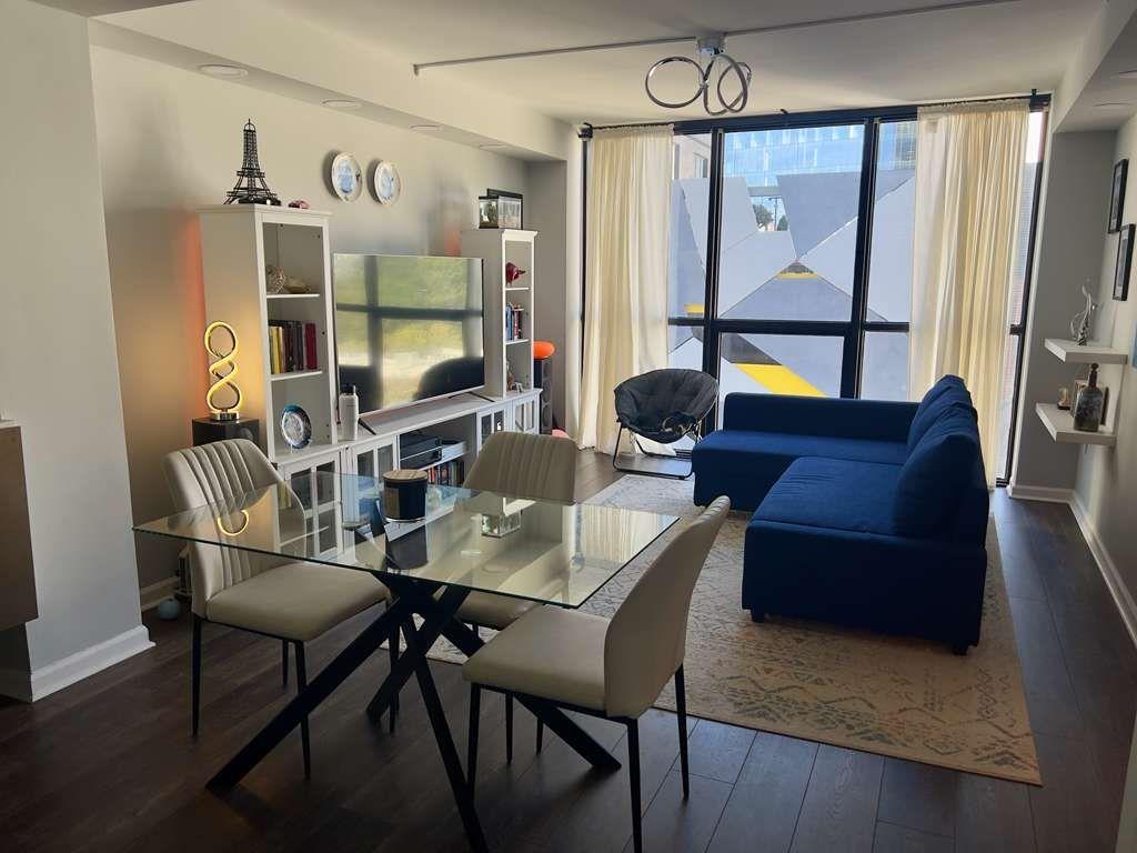a living room with furniture a flat screen tv and a floor to ceiling window