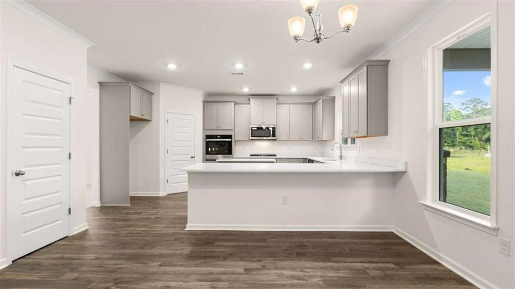 13593 Whitman Lane Covington, GA 30014 - Photo 14 of 25 a large white kitchen with wooden floor and a window