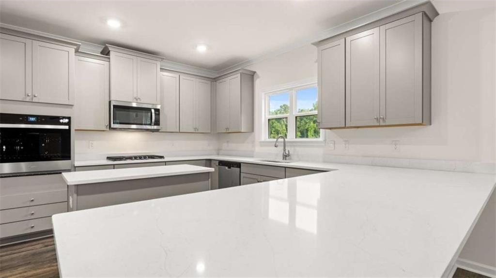 13593 Whitman Lane Covington, GA 30014 - Photo 15 of 25 a large kitchen with granite countertop a sink a stove a microwave a counter space and cabinets