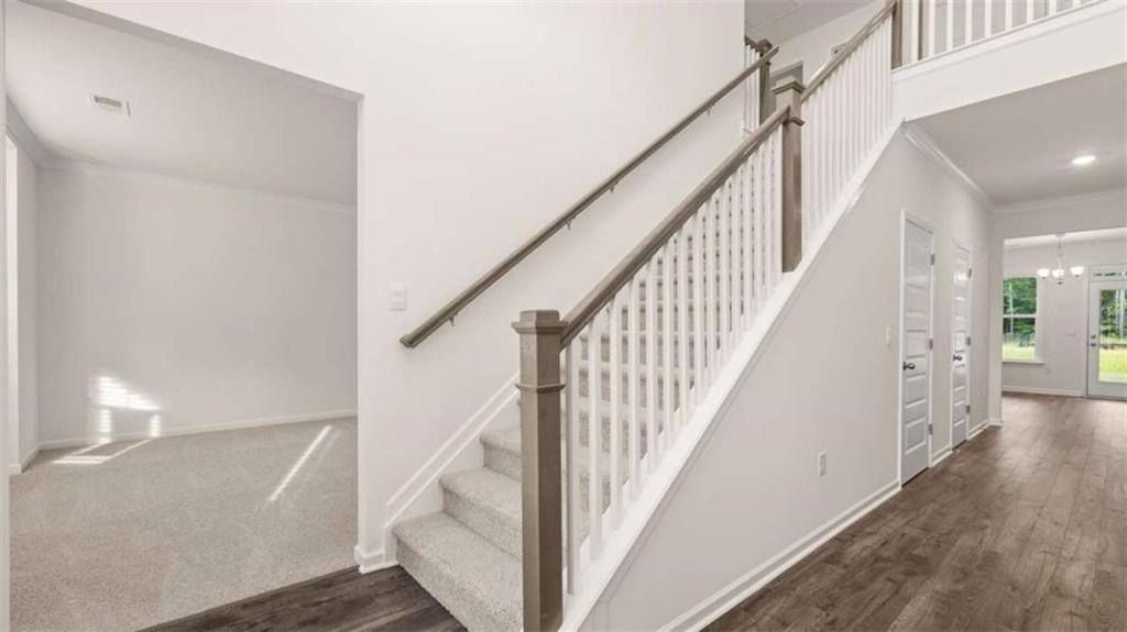 13593 Whitman Lane Covington, GA 30014 - Photo 7 of 25 a view of staircase with wooden floor and fan