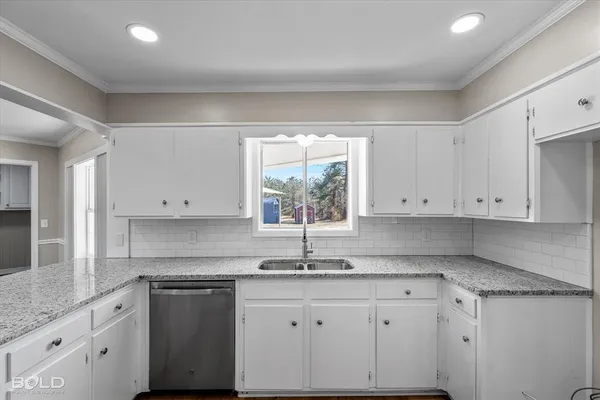 a kitchen with granite countertop white cabinets white appliances and a sink