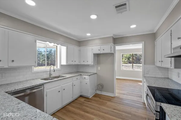 a kitchen with a sink window and cabinets