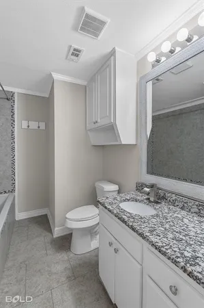 a bathroom with a granite countertop sink a toilet and a mirror