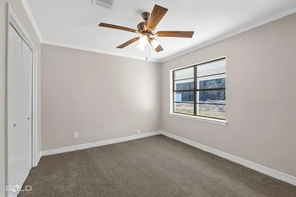 an empty room with a window and a fan