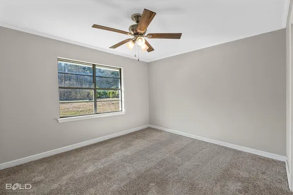 an empty room with windows and fan