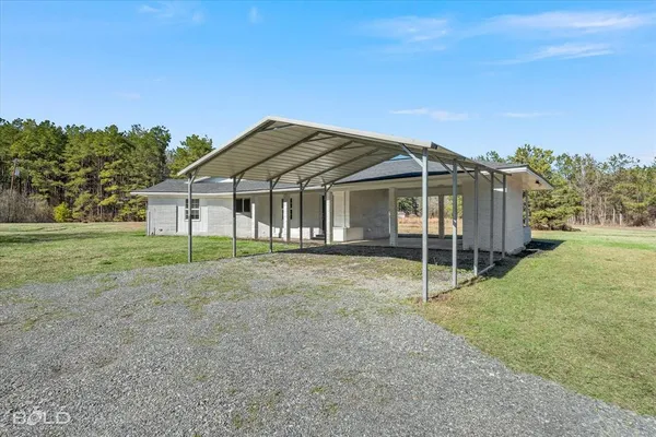 a view of a house with backyard and trees