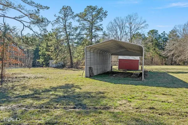 a backyard of a house with barbeque oven and trees