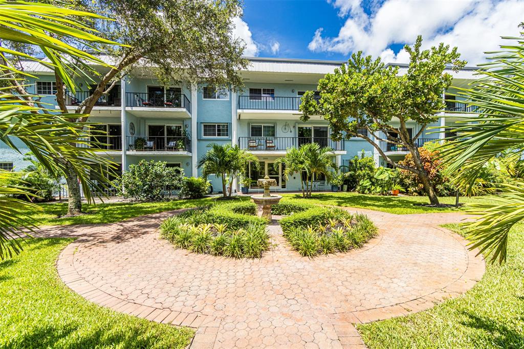 3000 Northeast 5th Terrace, Unit 110A Wilton Manors, FL 33334 - Photo 1 of 30 a front view of a house with a yard