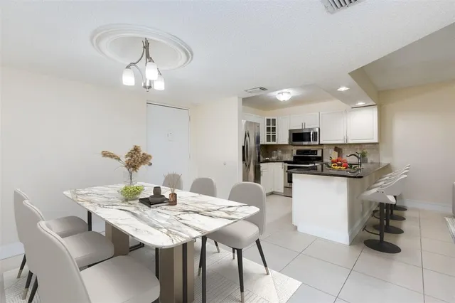 a kitchen with a dining table chairs and microwave