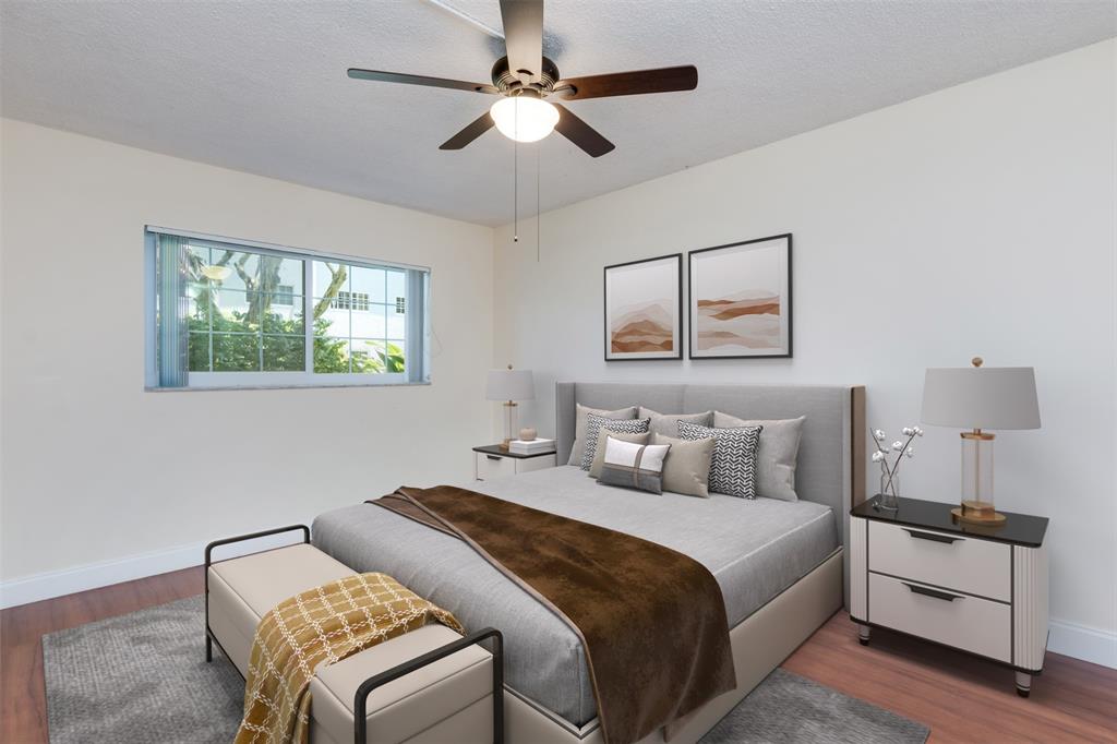 3000 Northeast 5th Terrace, Unit 110A Wilton Manors, FL 33334 - Photo 18 of 30 a bedroom with a bed and a chandelier