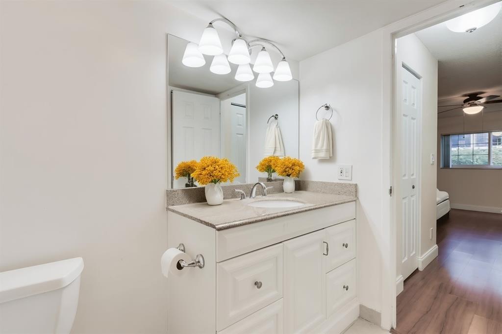 3000 Northeast 5th Terrace, Unit 110A Wilton Manors, FL 33334 - Photo 20 of 30 a bathroom with a sink a toilet and a mirror