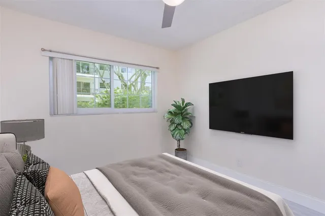 a bedroom with a flat screen tv and a potted plant