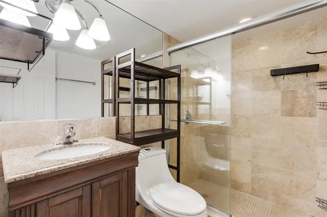 a bathroom with a granite countertop sink toilet and shower