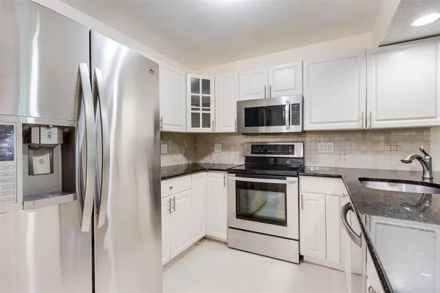 a kitchen with stainless steel appliances granite countertop a refrigerator stove and sink