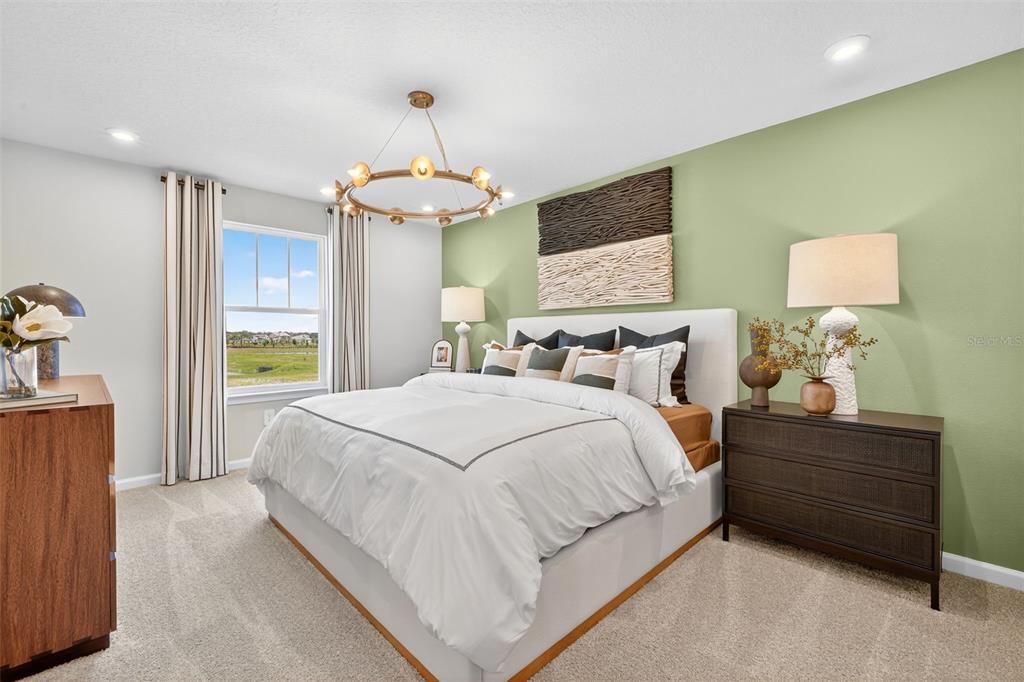 8846 Ginko Run Parrish, FL 34219 - Photo 11 of 24 a spacious bedroom with a bed and a chandelier