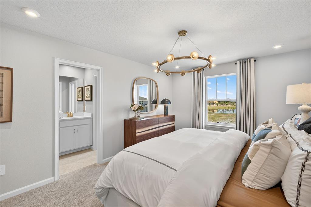 8846 Ginko Run Parrish, FL 34219 - Photo 12 of 24 a bedroom with a large bed and a chandelier