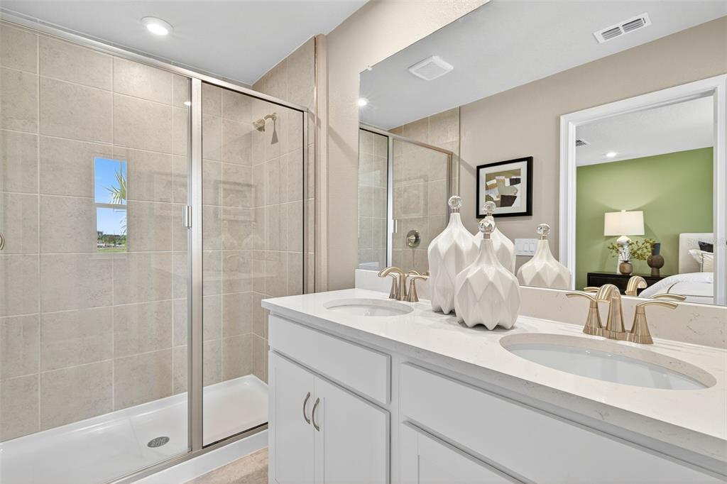 8846 Ginko Run Parrish, FL 34219 - Photo 13 of 24 a bathroom with a double vanity sink mirror and shower