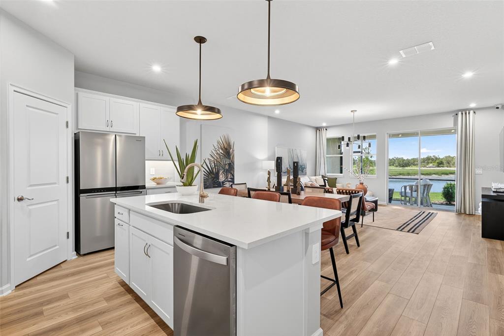 8846 Ginko Run Parrish, FL 34219 - Photo 6 of 24 a kitchen with stainless steel appliances kitchen island a large island in the center