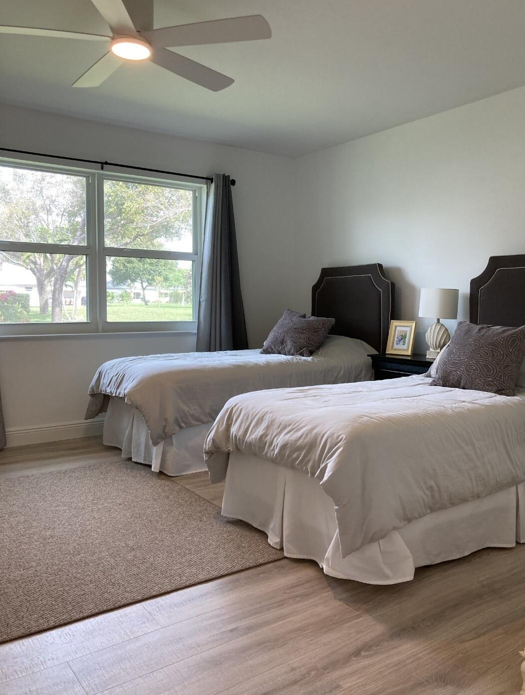 1155 South Drive Circle, Unit A Delray Beach, FL 33445 - Photo 18 of 21 a bedroom with two beds and a large window