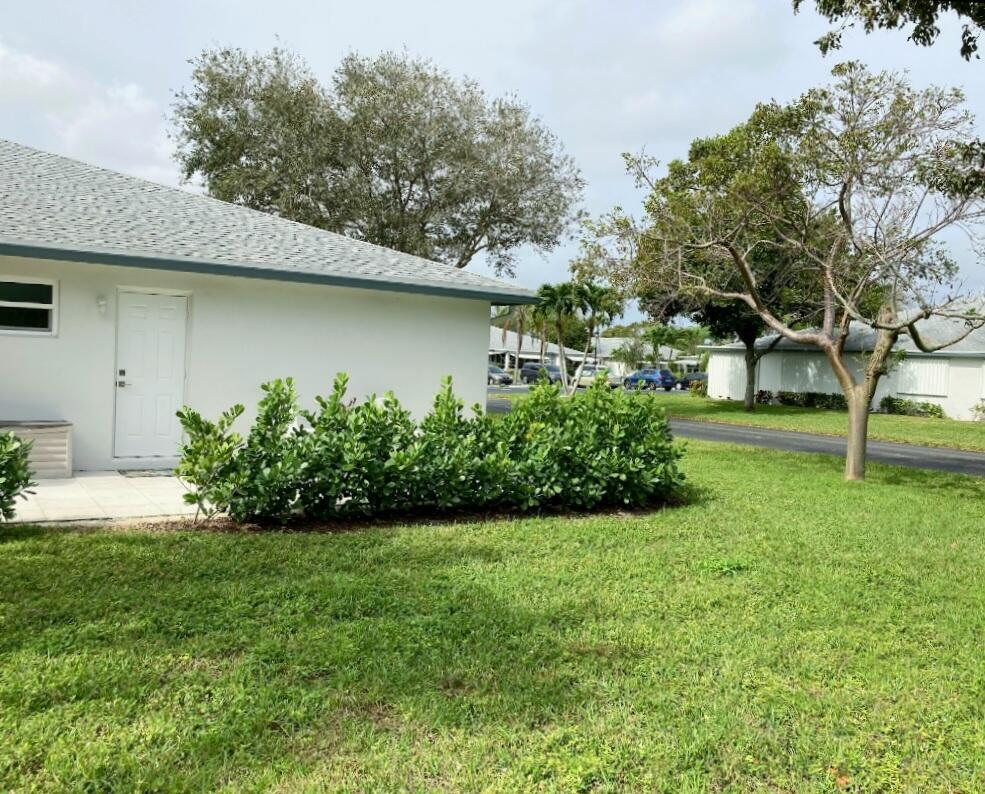 1155 South Drive Circle, Unit A Delray Beach, FL 33445 - Photo 4 of 21 a front view of a house with a yard