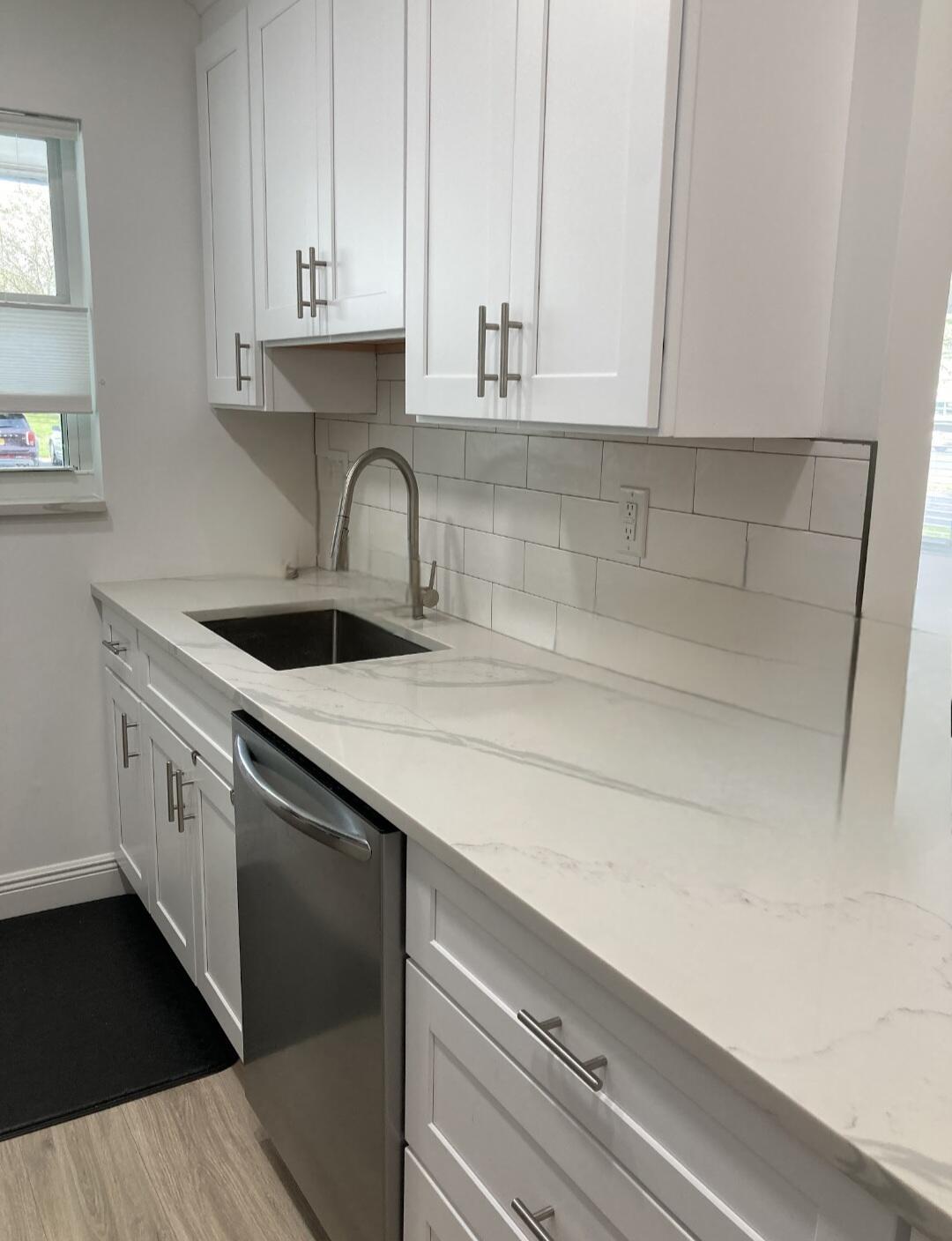 1155 South Drive Circle, Unit A Delray Beach, FL 33445 - Photo 10 of 21 a kitchen with granite countertop white cabinets and sink