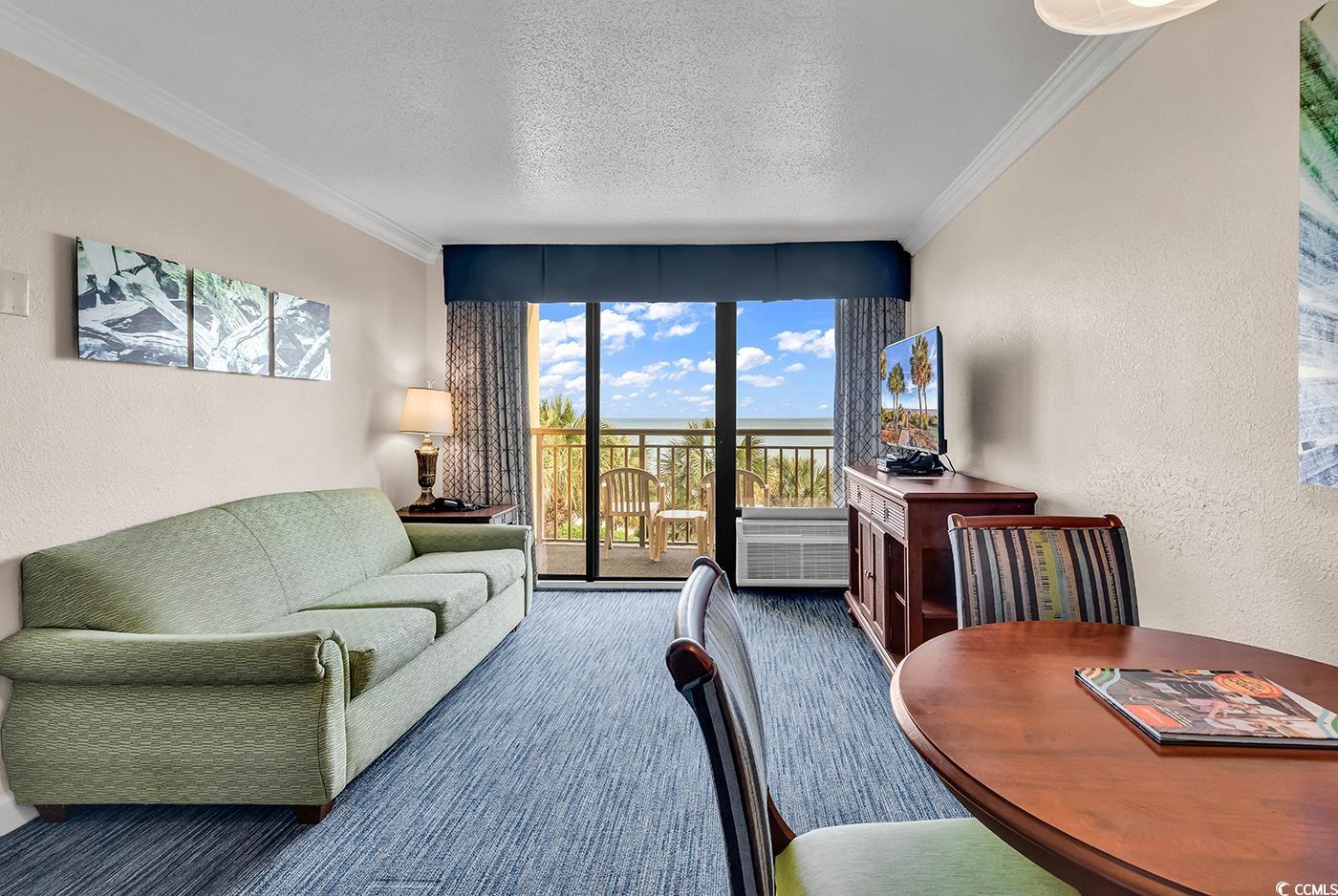 1202 North Ocean Boulevard, Unit 310 Myrtle Beach, SC 29577 - Photo 2 of 29 Living room featuring a textured wall, a textured ceiling, crown molding, and expansive windows