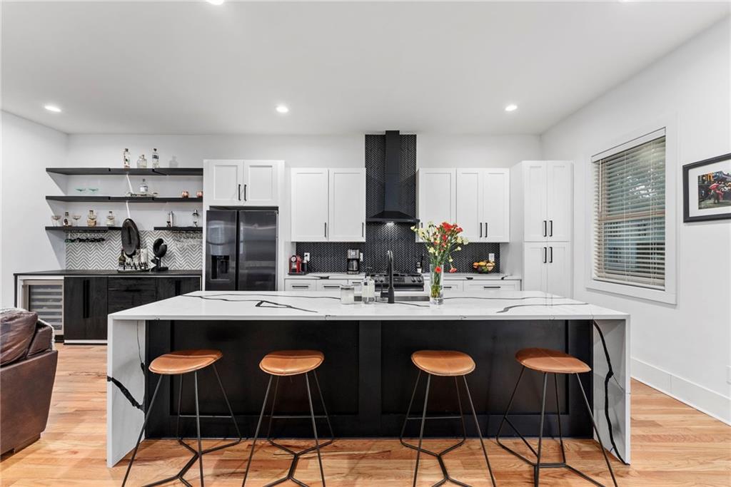 210 Locust Street Northeast Atlanta, GA 30317 - Photo 11 of 54 a kitchen with stainless steel appliances kitchen island granite countertop a sink and cabinets