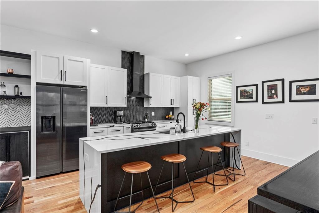 210 Locust Street Northeast Atlanta, GA 30317 - Photo 13 of 54 a kitchen with stainless steel appliances granite countertop a sink a stove a refrigerator cabinets and chairs