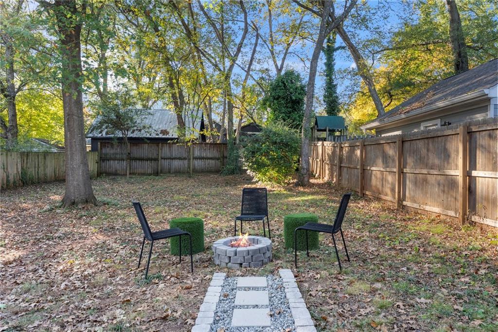 210 Locust Street Northeast Atlanta, GA 30317 - Photo 44 of 54 a view of a patio with table and chairs potted plants and large tree
