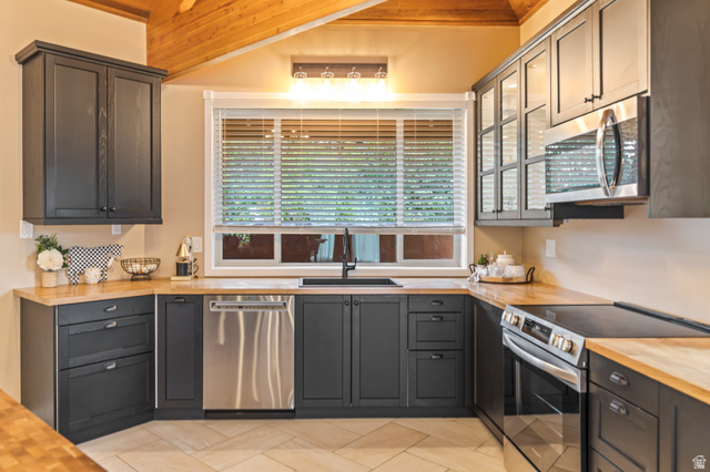 460 Omni Point Road Central Valley, UT 84754 - Photo 27 of 101 Kitchen featuring dark cabinetry, wood-finish countertops, and stainless steel appliances including a built-in microwave, dishwasher, and range