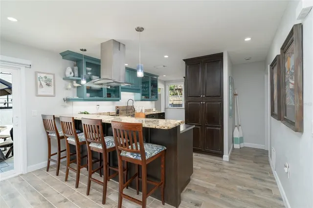 a dining area with stainless steel appliances kitchen island granite countertop a dining table and chairs