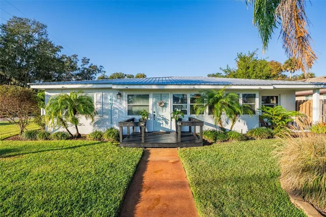 a view of a house with backyard sitting area and garden