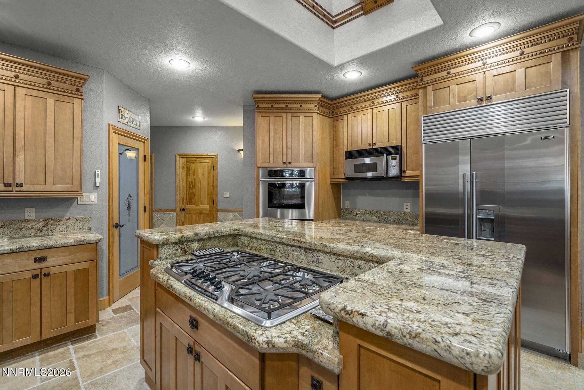 14501 Quail Rock Court Reno, NV 89511 - Photo 13 of 42 a kitchen with kitchen island granite countertop a stove refrigerator and cabinets