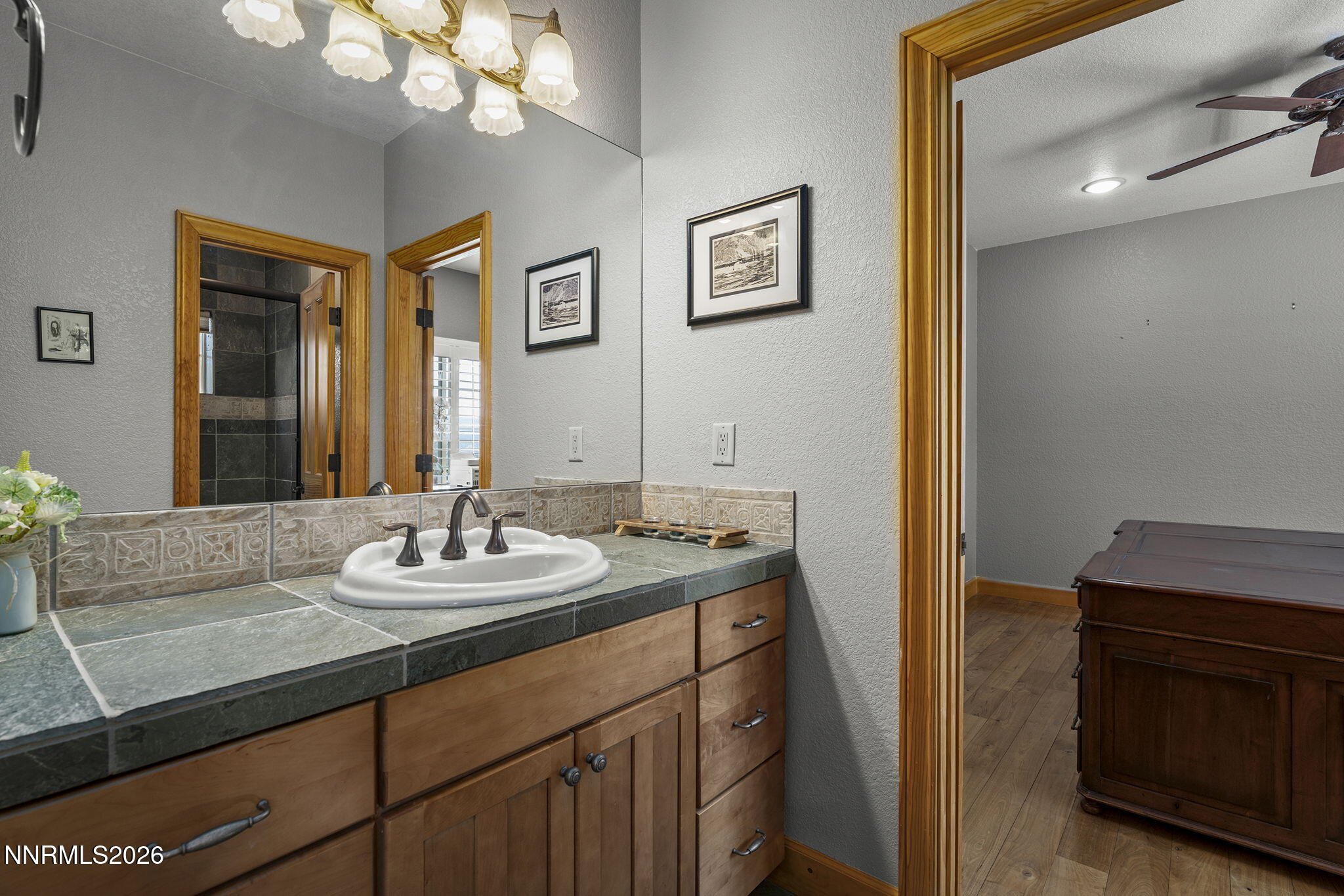 14501 Quail Rock Court Reno, NV 89511 - Photo 33 of 42 a bathroom with a granite countertop sink a large mirror and a light fixture