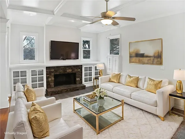 a living room with furniture a flat screen tv and a fireplace